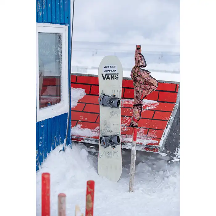 اسنوبرد DRAKE BATTLE RUSTY 2025 کنار کابین در قله پیست اسکی